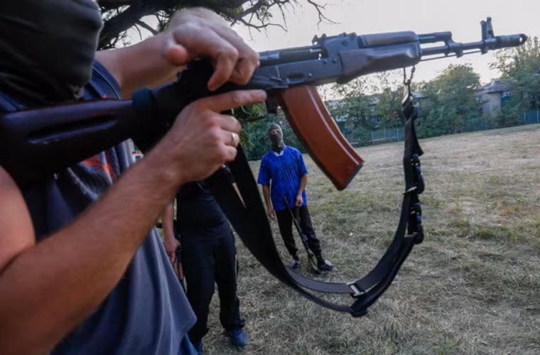 Người tình nguyện tập sử dụng súng.