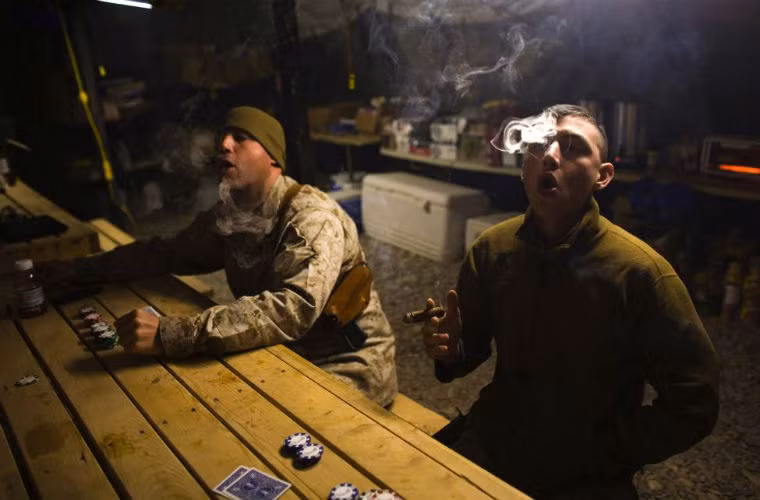 Lính Thủy đánh bộ Mỹ hút xì gà khi đang chơi bài ở căn cứ.