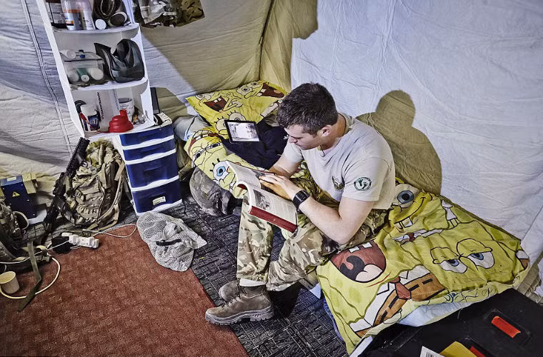 Một người lính tranh thủ đọc sách trong giờ nghỉ.