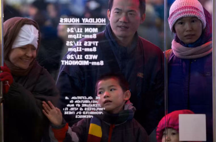 Cậu bé háo hức chờ đến lượt vào mua sắm cùng gia đình.