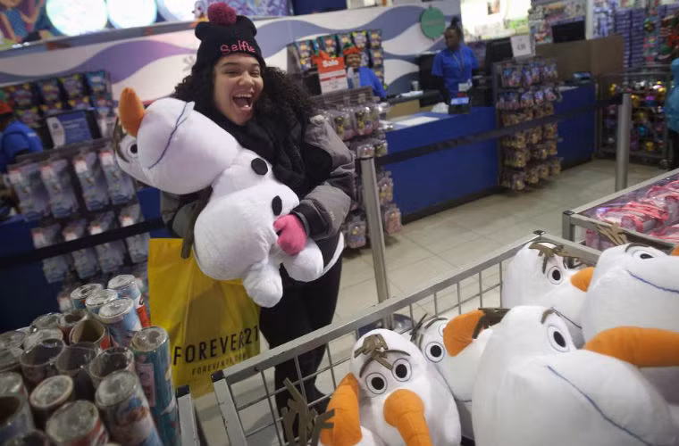 Người phụ nữ tỏ vẻ vui sướng vì mua được con búp bê với giá rẻ.