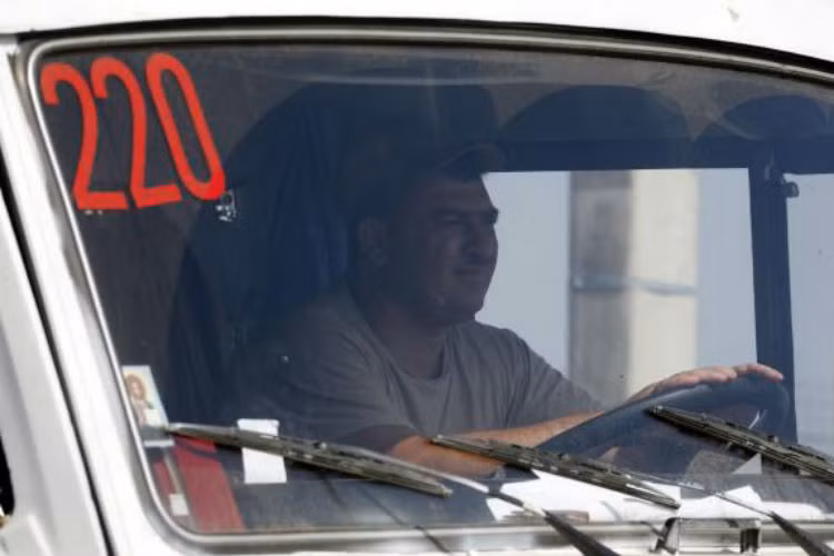 Lái xe trên một chiếc xe chở hàng cứu trợ của Nga tiến vào Ukraine.