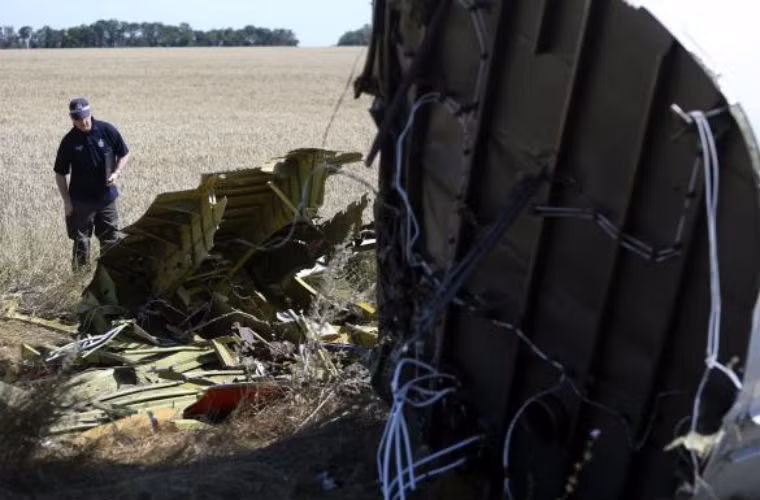 Một chuyên gia đang xét xét mảnh vỡ của máy bay MH17.