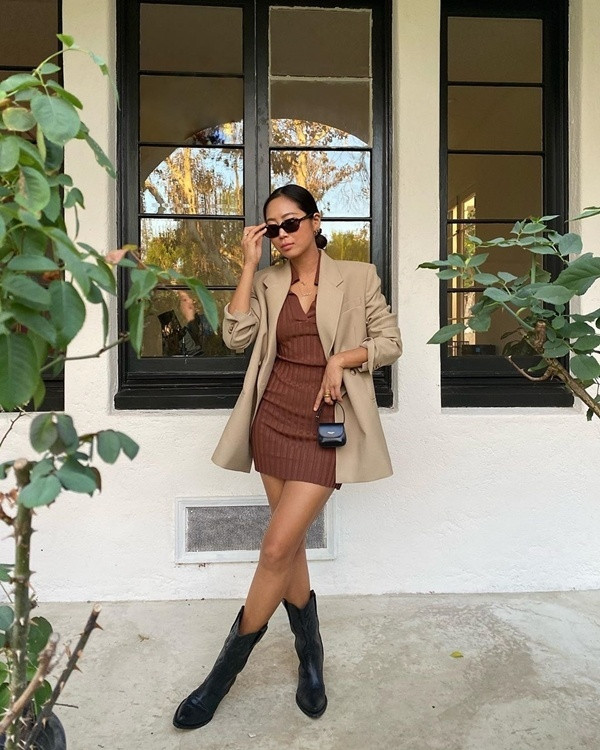 Aimee Song lại sử dụng những tông màu trung tính để tạo nên cho mình set đồ thu đơn giản mà vô cùng thời thượng. Blogger thời trang xứ Hàn diện váy liền dáng ôm màu nâu mix cùng blazer phủ tông be, khéo kết hợp thêm phụ kiện ton sur ton đen như boots da, túi xách mini và kính mắt.
