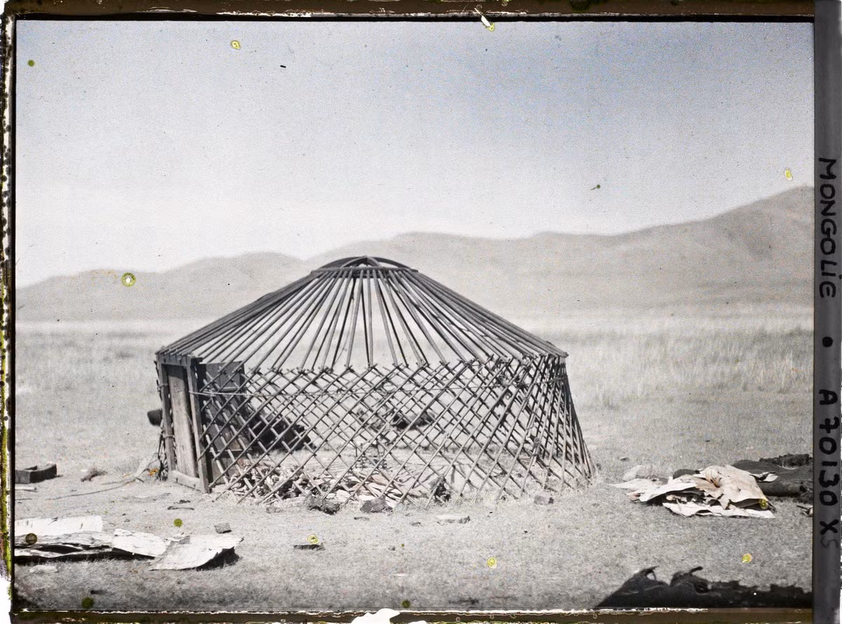 Một lều yurt trơ khung. Các tấm da dùng để bọc ngoài nằm vương vãi xung quanh.