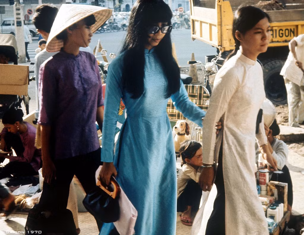 Hai cô gái áo dài bước trên vỉa hè trước thương xá TAX, góc Lê Lợi - Nguyễn Huệ, 1970.