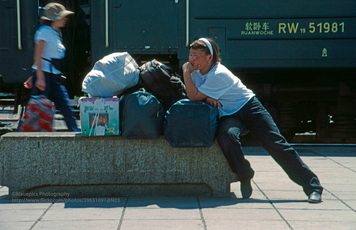 Một vị khách ngồi bên đống hành lý ở ga Ulan Bator.