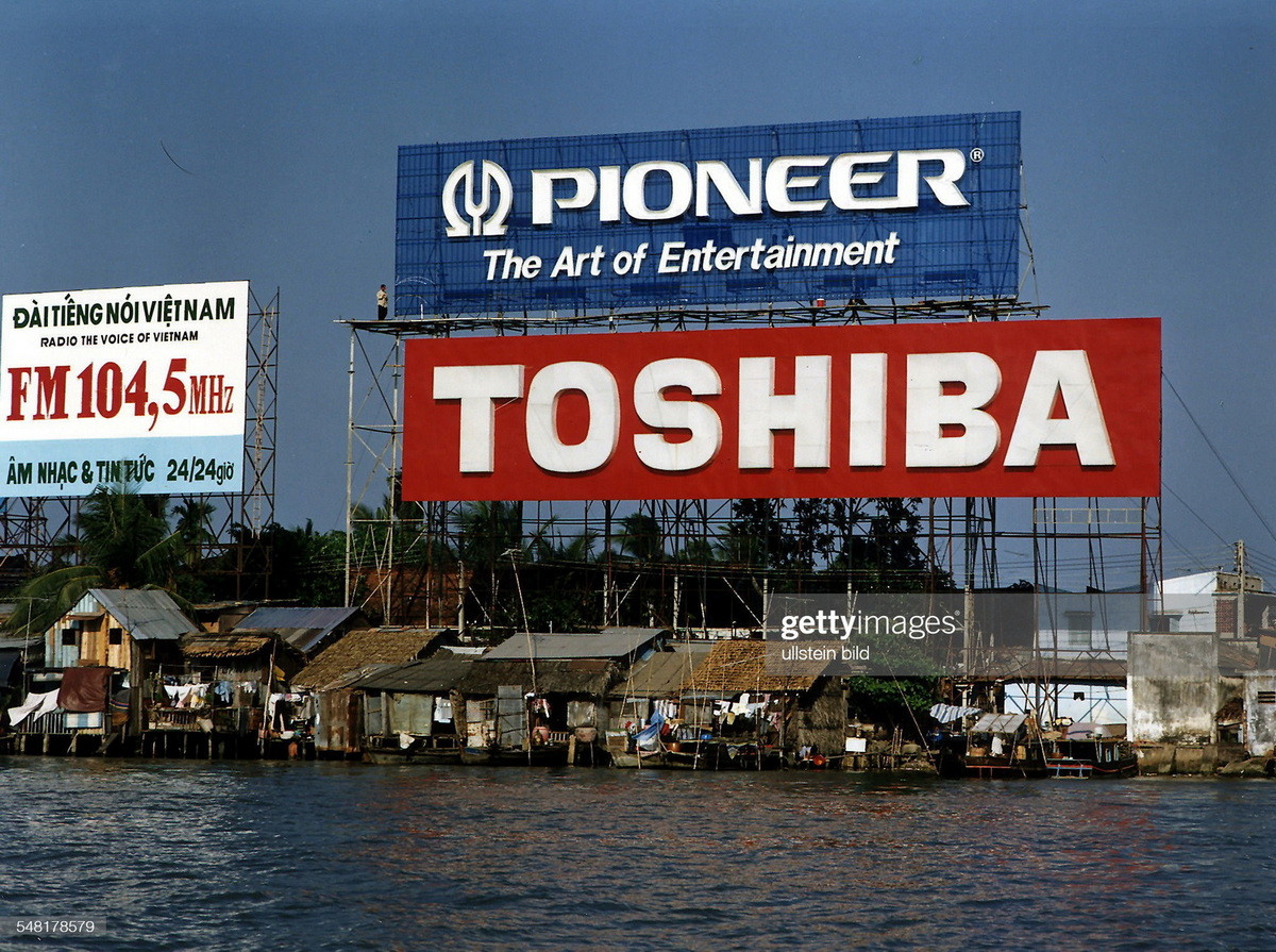 Pa-nô quảng cáo khổng lồ phía trên những ngôi nhà tạm bợ bên sông Sài Gòn ở bán đảo Thủ Thiêm.