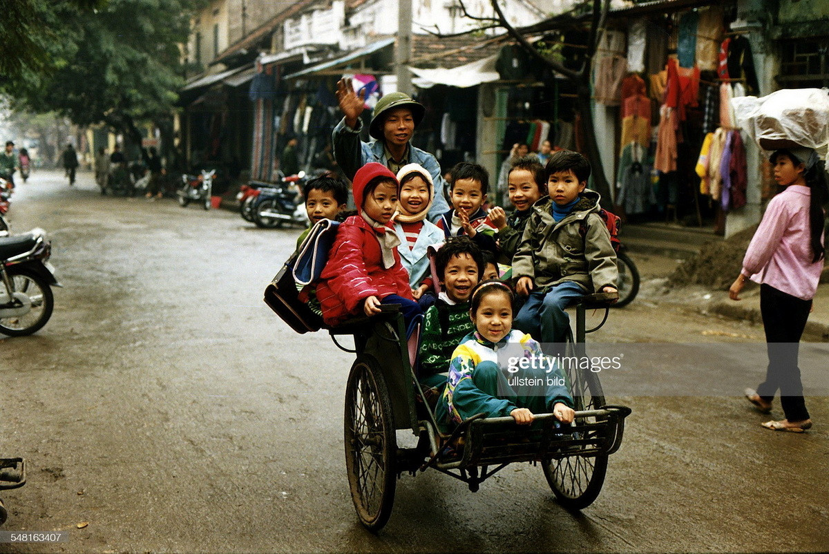 Xích lô chở học sinh tiểu học trên một con đường ở Hà Nội, Việt Nam năm 1995.