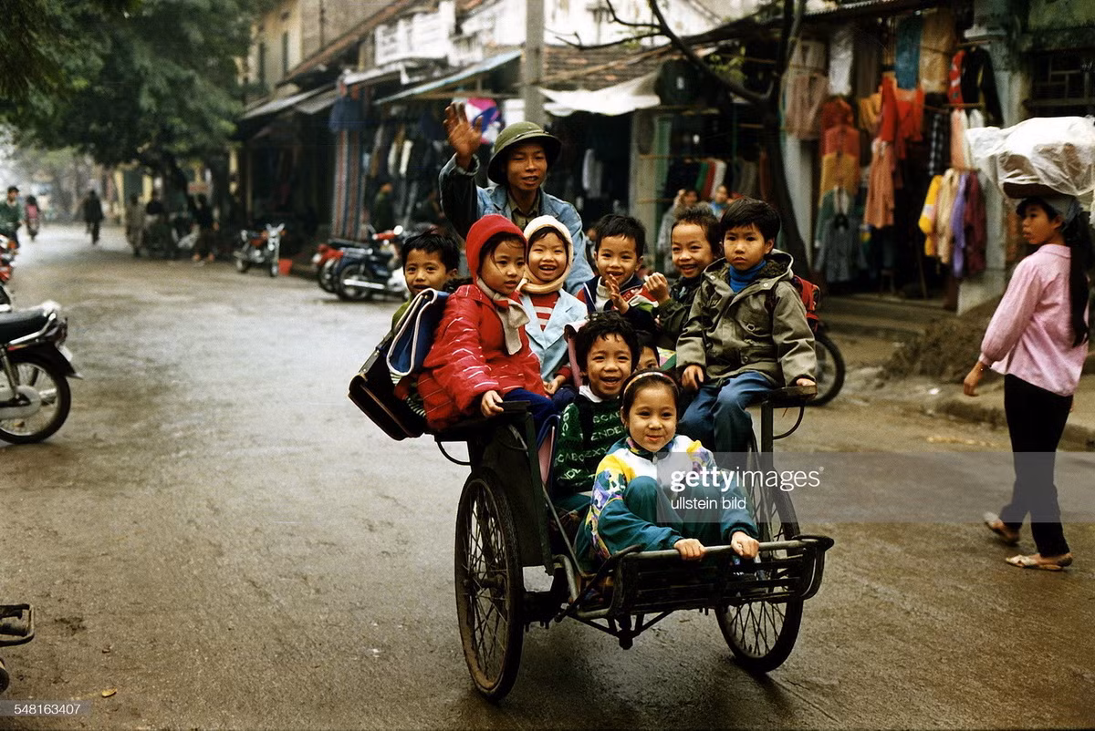 Xích lô chở học sinh tiểu học trên một con đường ở Hà Nội, Việt Nam năm 1995.