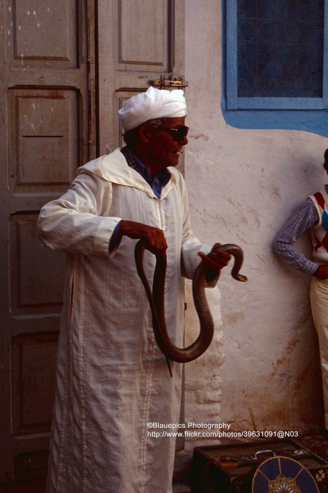 Người đàn ông hành nghề biểu diễn với rắn trên đường phố.