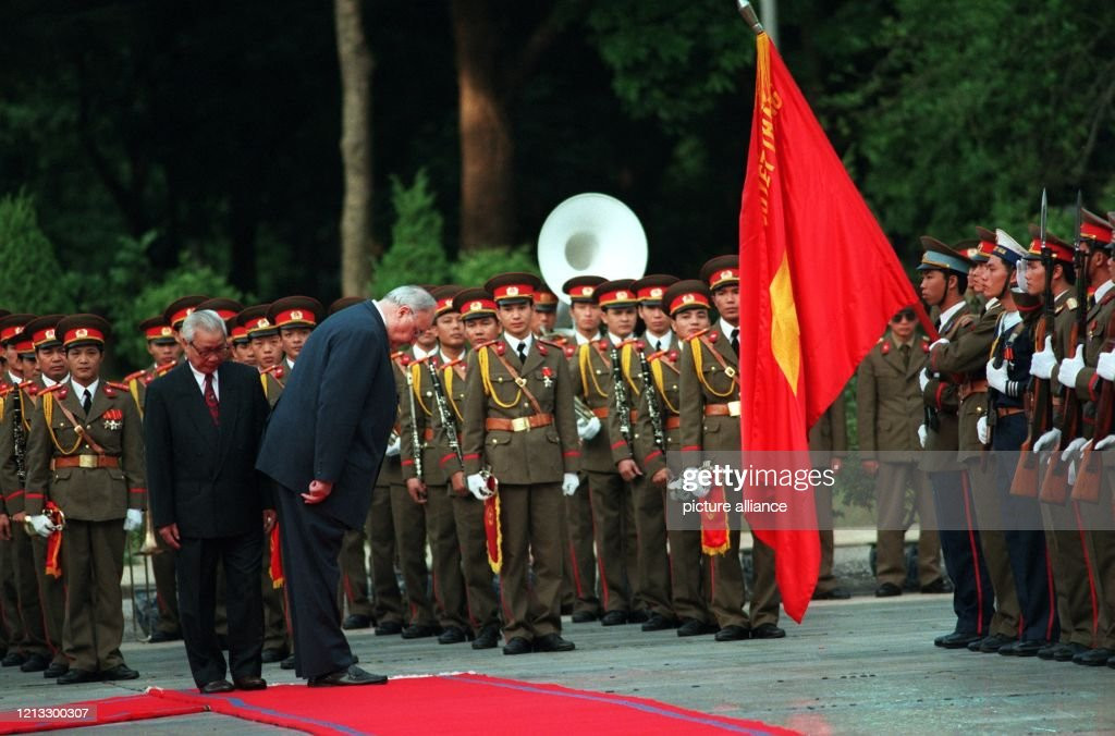 Thủ tướng Đức Helmut Kohl cúi chào trước quốc kỳ Việt Nam trước khi bước xuống phía trước đội hình danh dự với Thủ tướng Võ Văn Kiệt tại Phủ Chủ tịch ở Hà Nội, 16/11/1995. Ảnh: Tim Brakemeier/picture alliance via Getty Images.