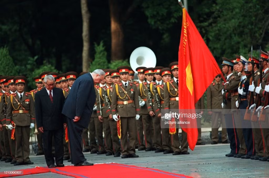 Thủ tướng Đức Helmut Kohl cúi chào trước quốc kỳ Việt Nam trước khi bước xuống phía trước đội hình danh dự với Thủ tướng Võ Văn Kiệt tại Phủ Chủ tịch ở Hà Nội, 16/11/1995. Ảnh: Tim Brakemeier/picture alliance via Getty Images.