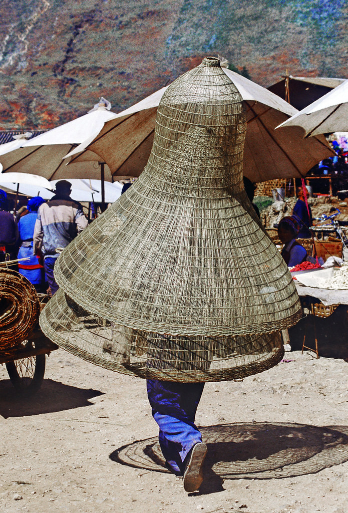 Một người mang dụng cụ đánh bắt cá ra chợ bán.