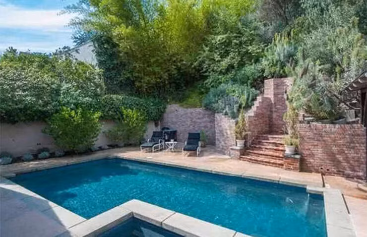 Nằm giữa một hồ bơi lấp lánh với sân lớn có mái che và những khu vườn bậc thang, còn có một bồn tắm nước nóng nằm trong khu vực lát đá phía trên.