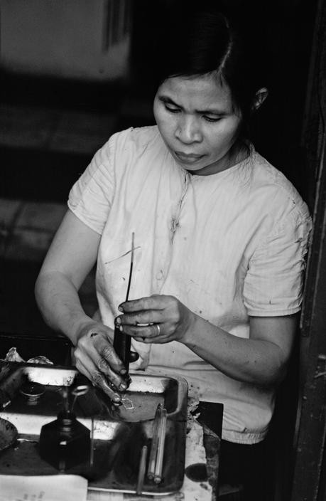 Người phụ nữ làm nghề đổ mực bút bi, một nghề trên phố phường Hà Nội thời bao cấp, năm 1980. Loạt ảnh phụ nữ Việt Nam thập niên 1980 trích từ dữ liệu ảnh của phóng viên nổi tiếng Philip Jones Griffiths trên website của hãng thông tấn Magnum.