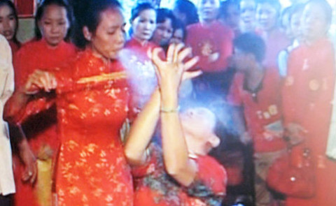 "Thánh" Hằng ở xã Xuân Tây, Cẩm Mỹ, Đồng Nai đang phun rượu và xoa khói thuốc để "chữa" bệnh cho người. Ảnh: Báo Công an TP HCM.