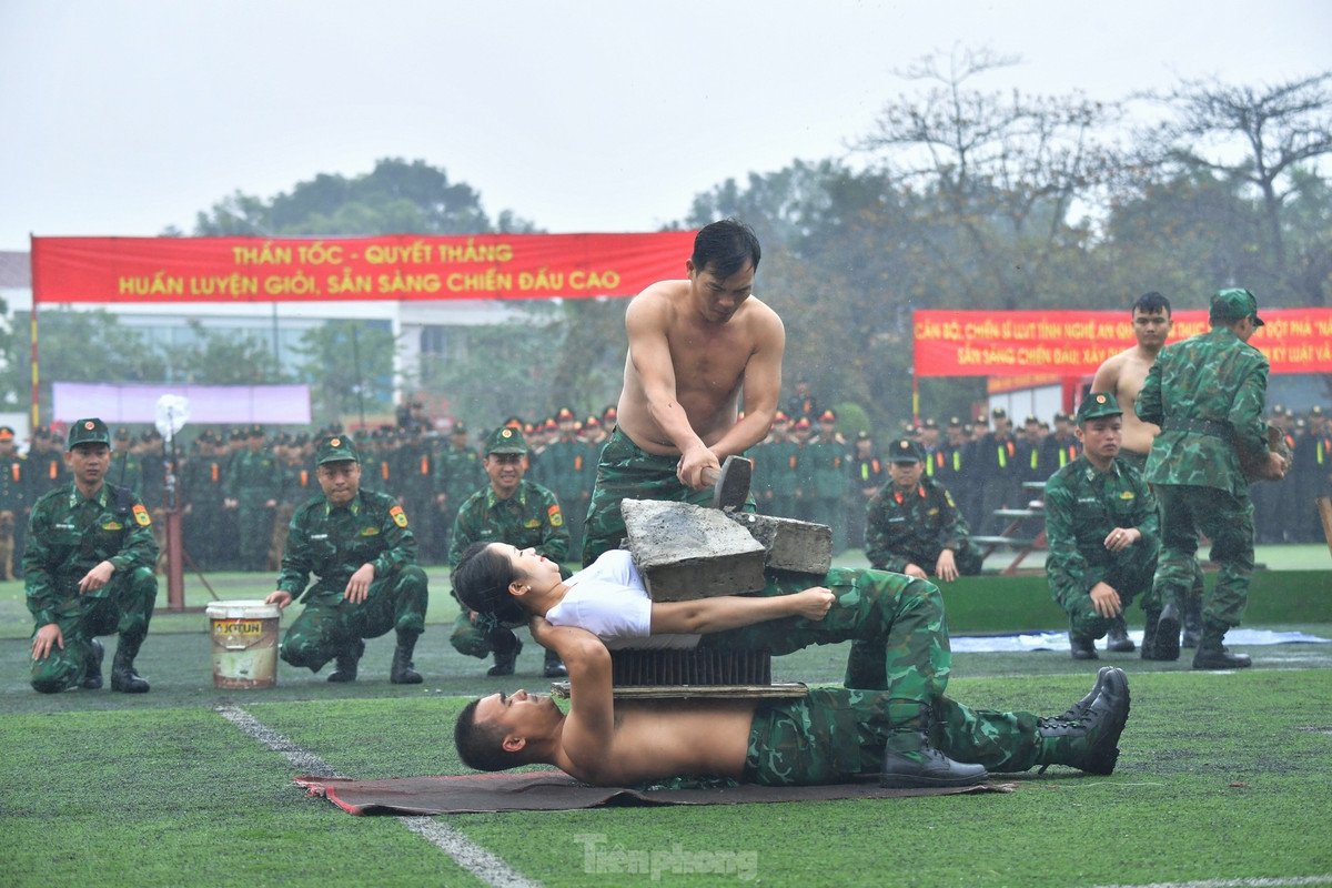 Hai cán bộ Biên phòng nằm trên thủy tinh vỡ, trên bàn chông để đồng đội dùng búa tạ đập vỡ tảng đá trên người.