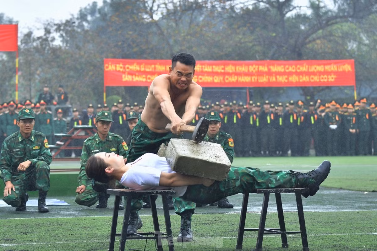 Nữ chiến sĩ để khối bêtông nặng hàng chục kg trên bụng vận khí cho đồng đội đập vỡ.