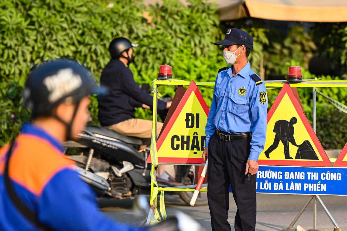 Nhân viên nhà thầu xuất hiện ở khu vực đầu vào đường tạm cùng biển cảnh báo để ngăn xe trọng tải lớn đi vào, gây nguy cơ hư hỏng kết cấu đường vành đai 3 trên cao.