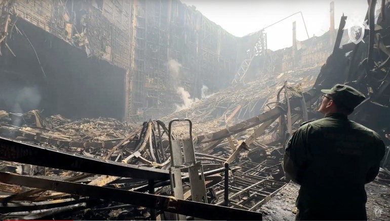 Một điều tra viên của Ủy ban Điều tra Nga kiểm tra phòng hòa nhạc bị thiêu rụi sau vụ tấn công.