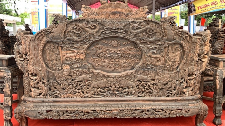 Ấn tượng nhất là chiếc ghế đại có chiều dài 2,8m, chiều cao khoảng gần 2m. Kích thước này cùng với những chi tiết lèo lá long - lân - quy - phụng được chạm trổ cả ở mặt trước, mặt sau, tay nắm khiến nó trở nên cực kỳ thu hút. (Ảnh mặt sau chiếc ghế)