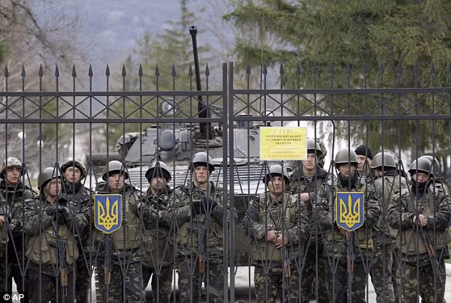 Binh sĩ Ukraine đứng gác trước cổng một căn cứ quân sự ở Privolnoye, Crimea.