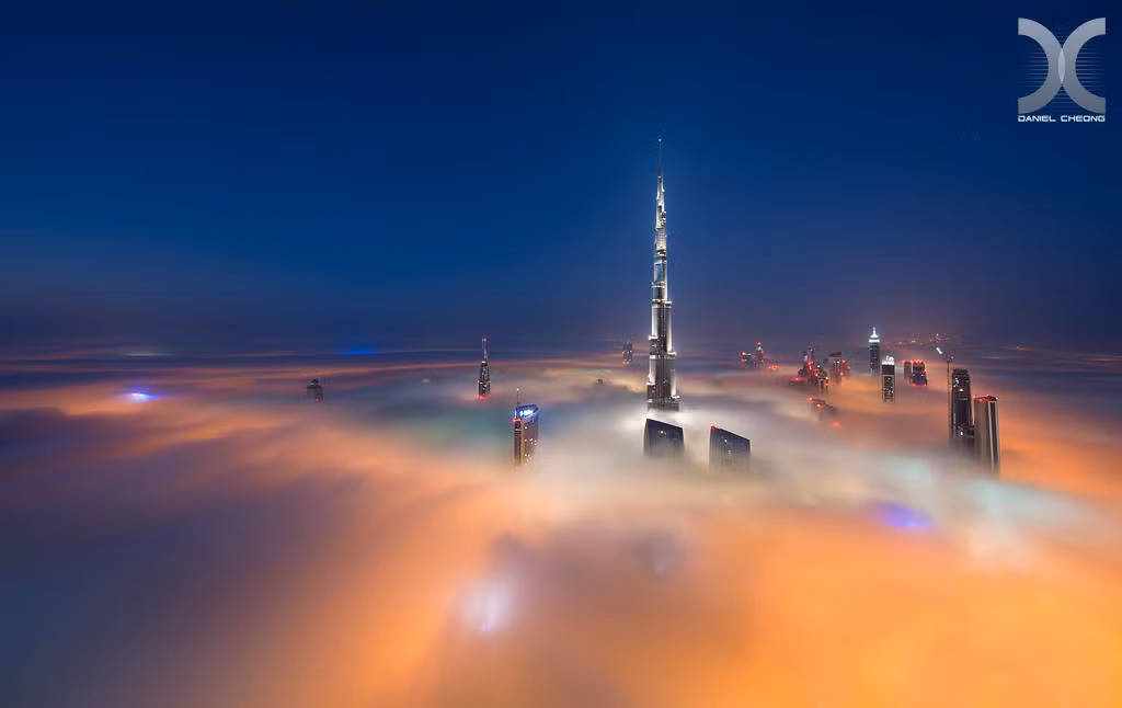 Ánh đèn điện rực rỡ của Dubai nhuộm vàng biển sương sớm bồng bềnh.