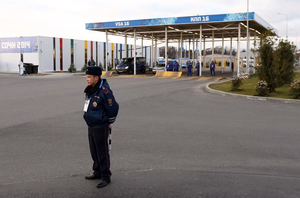 Một nhân viên an ninh đứng ở vòng ngoài một trạm kiểm soát xe trước lối vào Công viên Olympic. Trong khi đó, tại cửa ngõ vào thành phố Sochi, cảnh sát và quân đội cắm chốt kiểm tra như tại khu vực biên giới thực sự. Trừ các trường hợp có thẻ đặc biệt, xe từ bên ngoài vào thành phố Sochi đã bị cấm đến hết tháng 3.