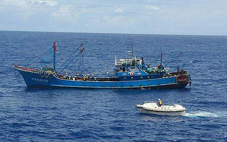 Một tàu tuần duyên Nhật Bản (màu trắng) áp sát, bắt giữ tàu cá Trung Quốc (màu xanh) đánh bắt trái phép trong vùng biển do Tokyo quản lý.