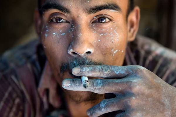 Nam nhân công tranh thủ hút thuốc giữa giờ nghỉ giải lao.