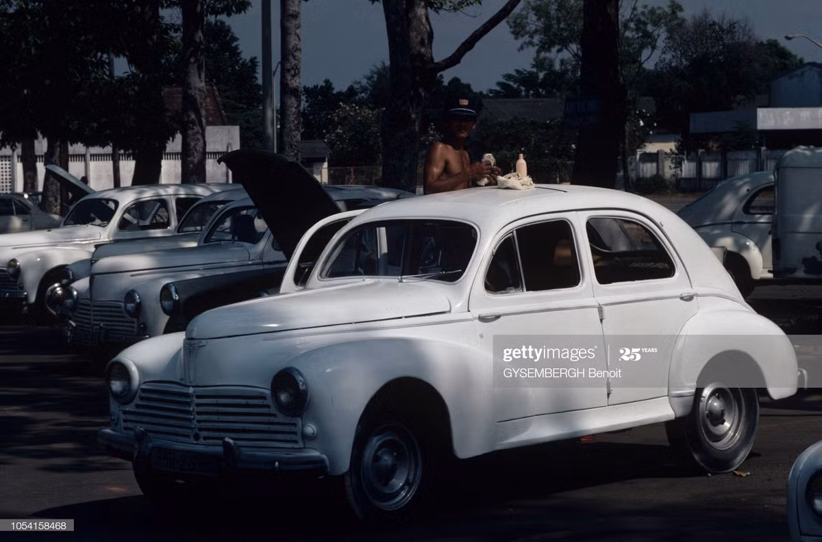 Người tài xế lau chùi chiếc xe Renault 4CV, TP HCM.