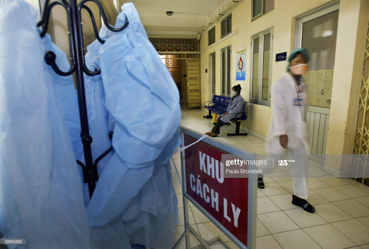 Một y tá bước đi dọc hành lang khu cách ly dành cho bệnh nhân mắc cúm gia cầm tại Bệnh viện Bệnh nhiệt đới Trung ương, một cơ sở y tế nằm trong khuôn viên Bệnh viện Bạch Mai, Hà Nội ngày 20/1/2004. Ảnh: Paula Bronstein/Getty Images.