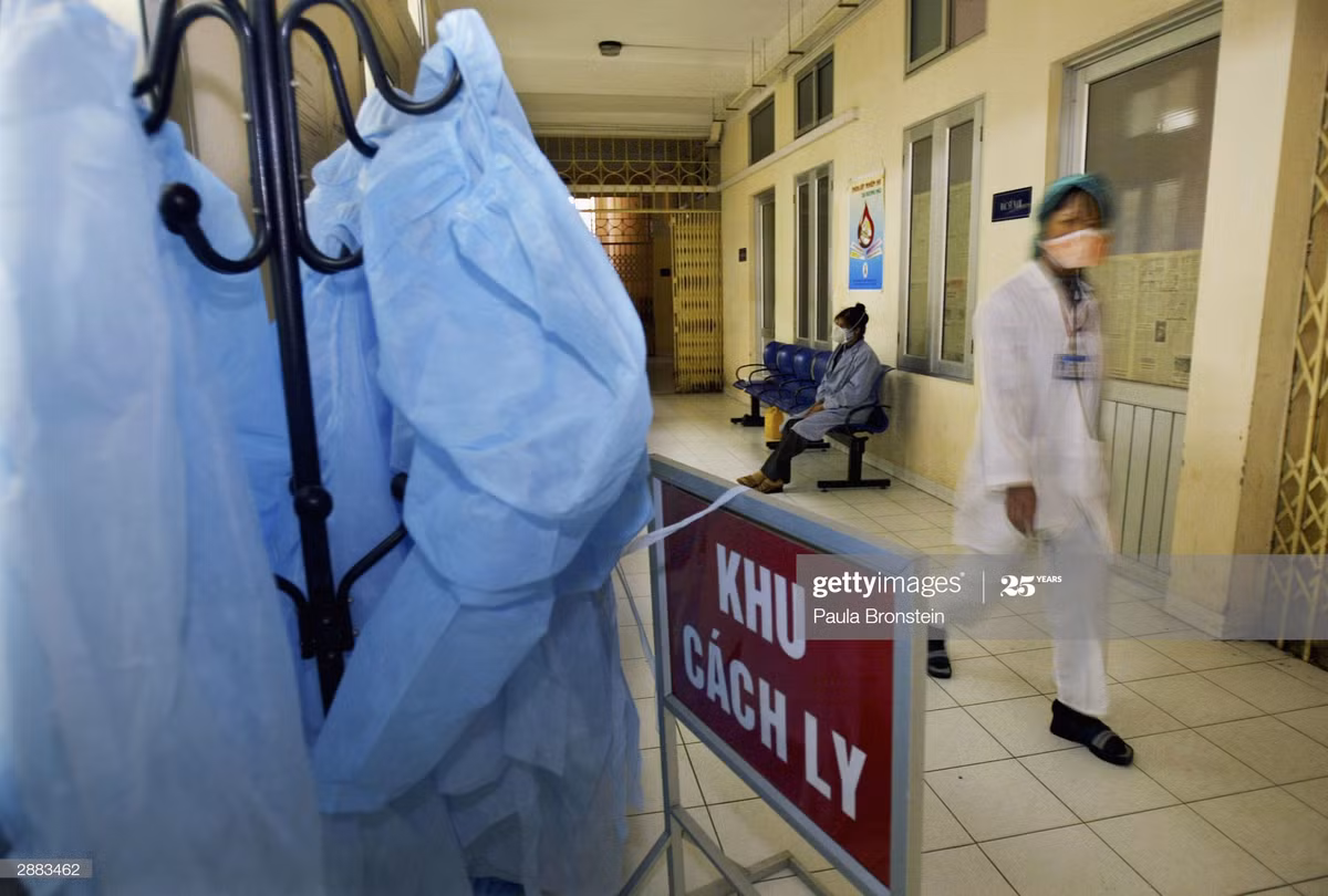 Một y tá bước đi dọc hành lang khu cách ly dành cho bệnh nhân mắc cúm gia cầm tại Bệnh viện Bệnh nhiệt đới Trung ương, một cơ sở y tế nằm trong khuôn viên Bệnh viện Bạch Mai, Hà Nội ngày 20/1/2004. Ảnh: Paula Bronstein/Getty Images.