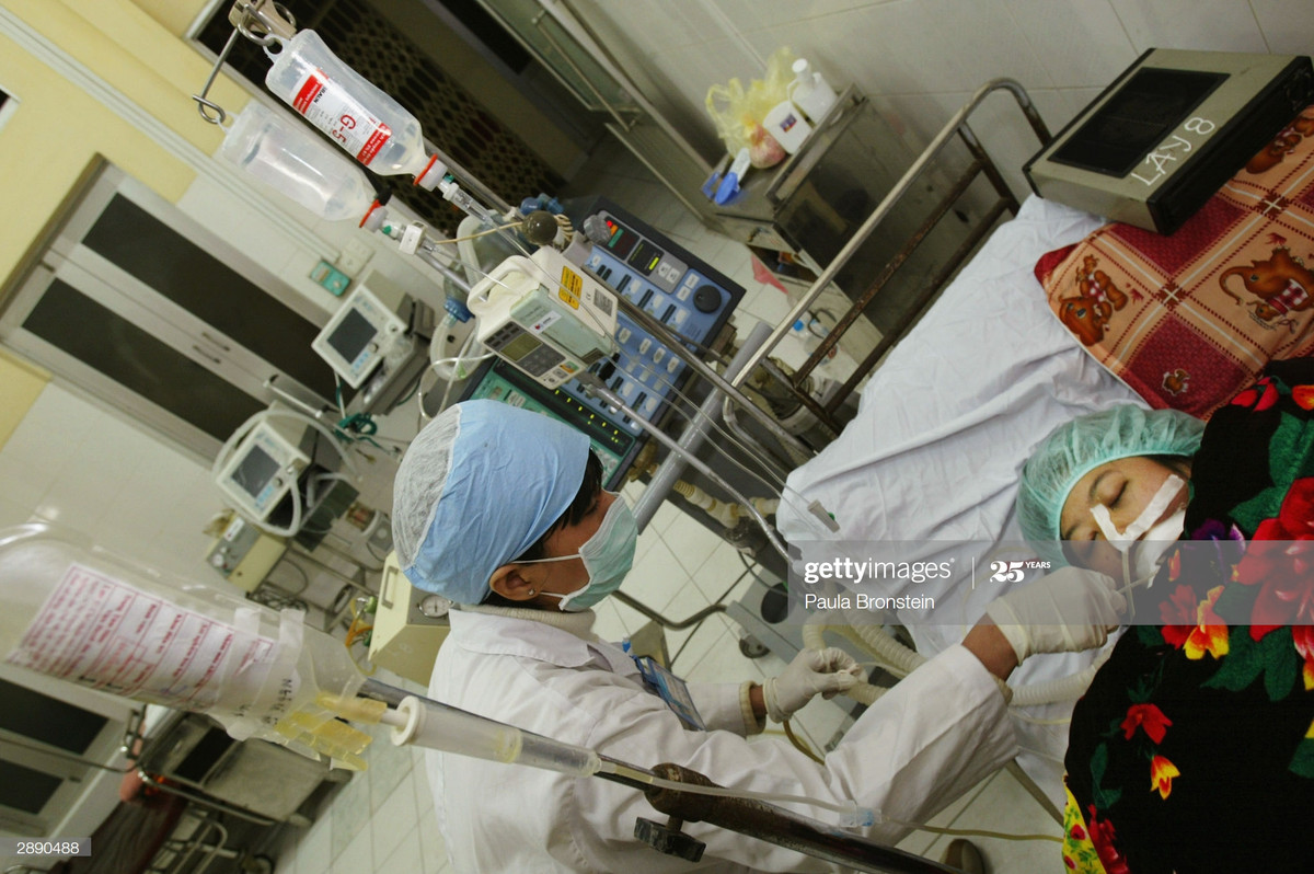 Một phụ nữ trong tình trạng bệnh nặng với hệ hô hấp bị tổn thương do cúm gia cầm được y tá chăm sóc tại Bệnh viện Bệnh nhiệt đới Trung ương, ngày 22/1/2004.