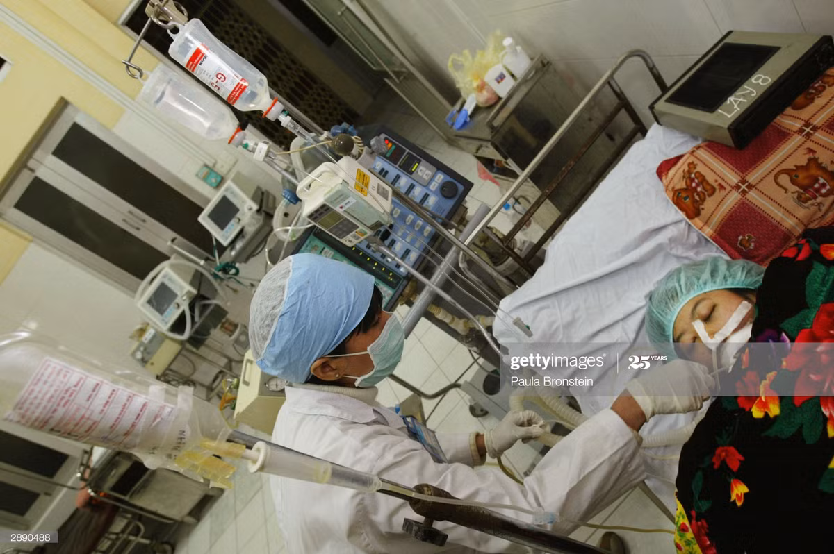 Một phụ nữ trong tình trạng bệnh nặng với hệ hô hấp bị tổn thương do cúm gia cầm được y tá chăm sóc tại Bệnh viện Bệnh nhiệt đới Trung ương, ngày 22/1/2004.