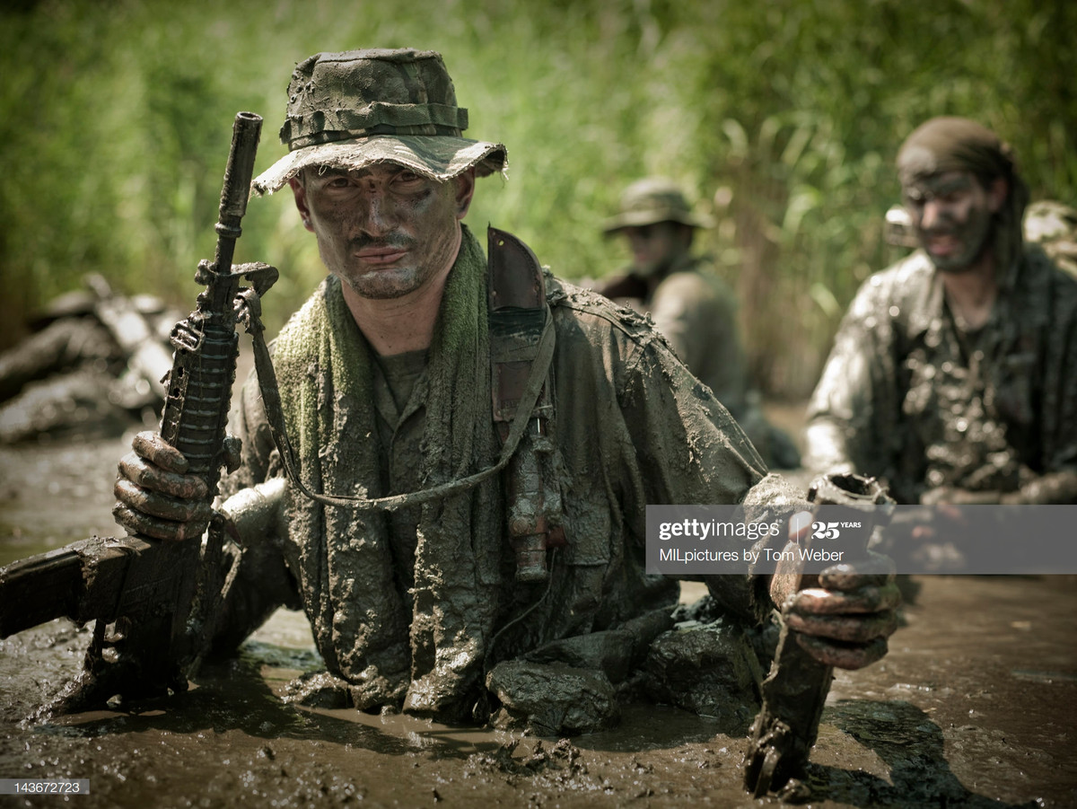 Lính Mỹ "tắm bùn" với khẩu M16 trong tay.