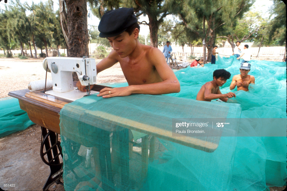 Những người ngư dân kiểm tra và vá lưới đánh cá bằng máy khâu ở Nha Trang, tháng 6/1993. Du khách quốc tế đã bắt đầu tìm đến Nha Trang vào thời điểm này.