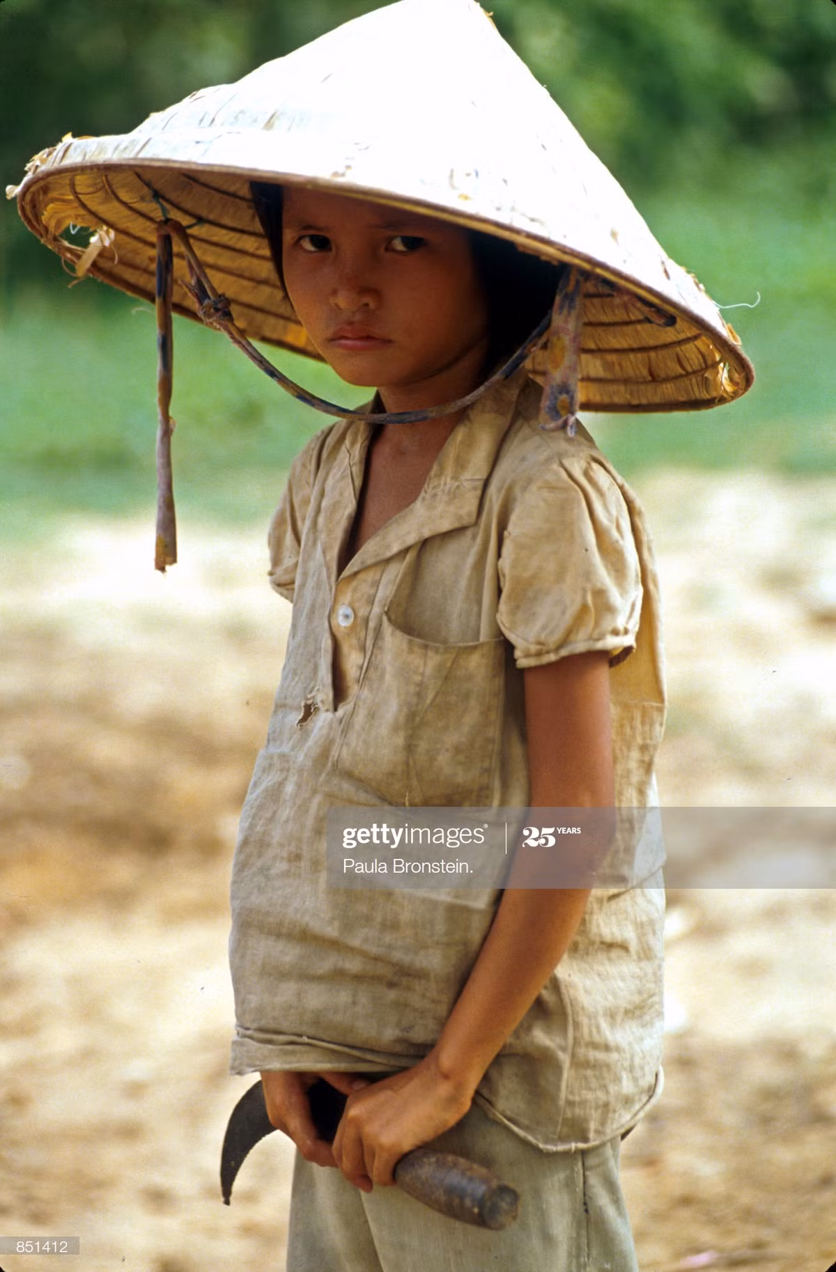 Một em bé giúp gia đình làm nông nghiệp ở khu vực Tây Nguyên, tháng 7/1993. Từ đầu thập niên 1990, vùng Tây Nguyên chứng kiến sự bùng nổ của ngành cà phê với diện tích và sản lượng gia tăng chóng mặt theo từng nằm, thu hút một lượng lớn lao động địa phương.