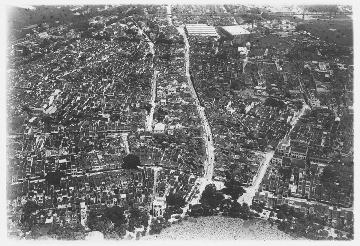 Toàn cảnh khu phố cổ Hà Nội. Phía dưới là hồ Hoàn Kiếm. Trục đường lớn ở giữa là trục Hàng Ngang - Hàng Đào, phía cuối trục này là chợ Đồng Xuân.