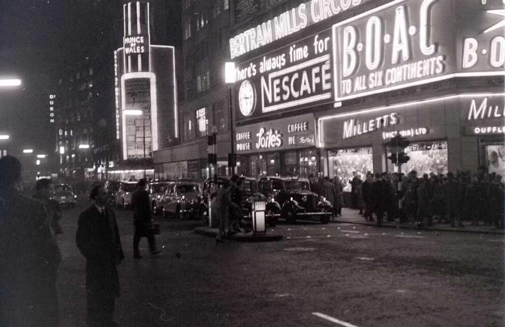 Phố Coventry lộng lẫy với ánh đèn neon tỏa ra từ các bảng hiệu, London ngày 1/3/1957.