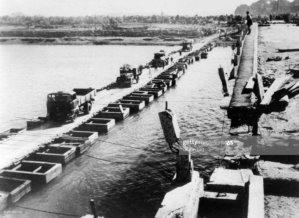 Các đoàn xe tiến vào Nam trên cầu phao mới dựng cạnh cây cầu bê tông bị máy bay Mỹ phá hỏng, miền Bắc Việt Nam năm 1968.