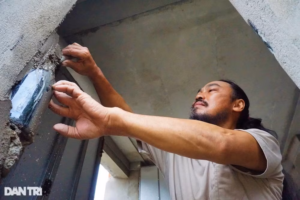 Ông Linh dùng xi măng để gắn chai vào tường. Việc này đòi hỏi phải kiên trì, tỉ mỉ và làm trong nhiều ngày.