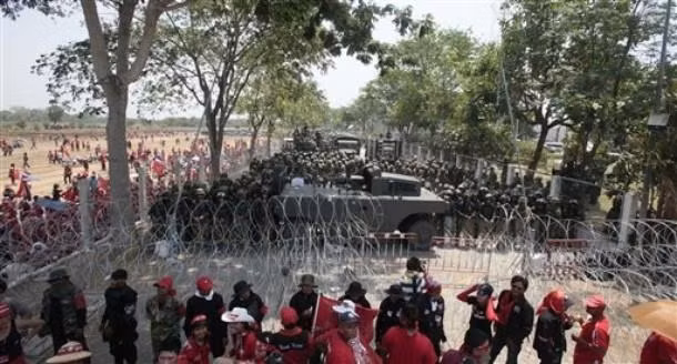 Cảnh sát Thái Lan dàn hàng đứng đối diện với người biểu tình qua một hàng rào dây thép gai trong cuộc biểu tình tháng 4/2010.