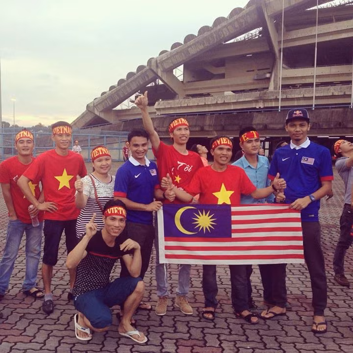 Hình ảnh những CĐV Việt Nam cầm trên tay lá quốc kỳ Malaysia trước sân vận động Shah Alam.