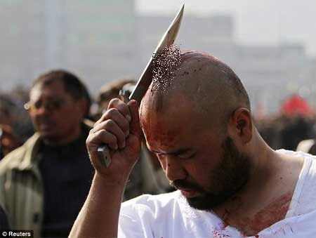 Những người đàn ông tham dự nghi lễ dùng lưỡi dao tự đánh lên lưng, lên đầu đến chảy máu để tôn vinh người anh hùng của họ. Ảnh: Reuters.