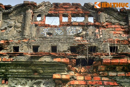 Phía trên cửa giữa có bốn chữ Hán ghép bằng sứ nhưng đã mất nhiều nét, hai bên trang trí cành đào có hai trái.