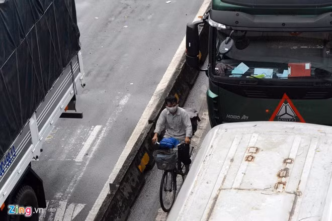 Một người bán bánh tét đạp xe chạy vào làn đường dành cho ôtô để bán hàng bất chấp tai nạn luôn chực chờ.