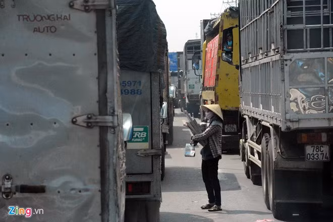 Hàng trăm phương tiện phải nhích từng chút một để vượt qua đoạn đường tạo điều kiện cho hơn chục người đẩy, xách, vác các loại hàng lao ra giữa đường, bám theo ôtô để bán hàng. Xôm tụ nhất là vào giữa trưa và cuối ngày.
