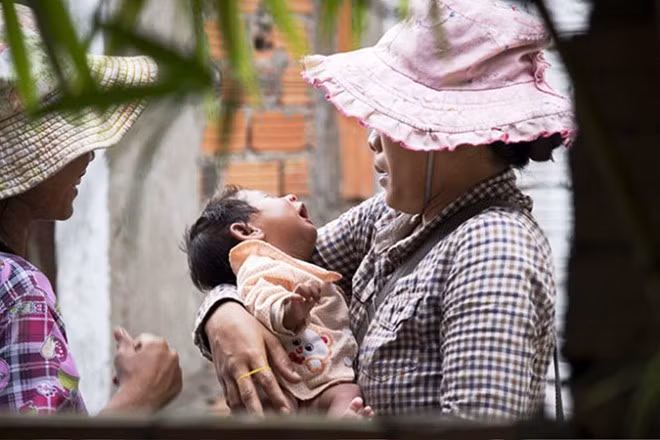 Một đứa trẻ được chuyền tay cho rất nhiều phụ nữ đưa đi kiếm ăn nhằm dễ động lòng trắc ẩn người đi đường.